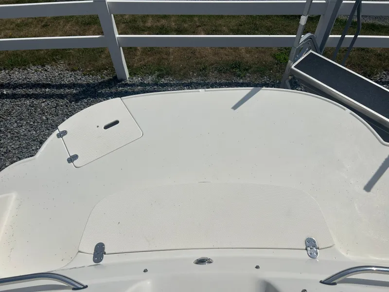 Slide: The Image of 2005 Stingray 250 LR boat deck with white railing and ladder. - 10