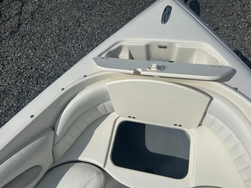 Slide: The Image of 2005 Stingray 250 LR boat interior with white seating and storage compartment. - 17