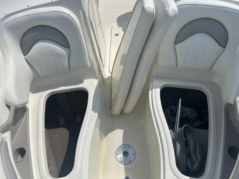 Slide: The Image of 2005 Stingray 250 LR boat interior with open storage compartments and white seating. - 18