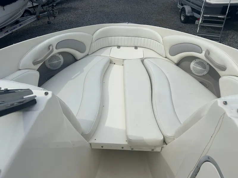 Slide: The Image of 2005 Stingray 250 LR boat interior with white cushioned seating and speakers. - 25