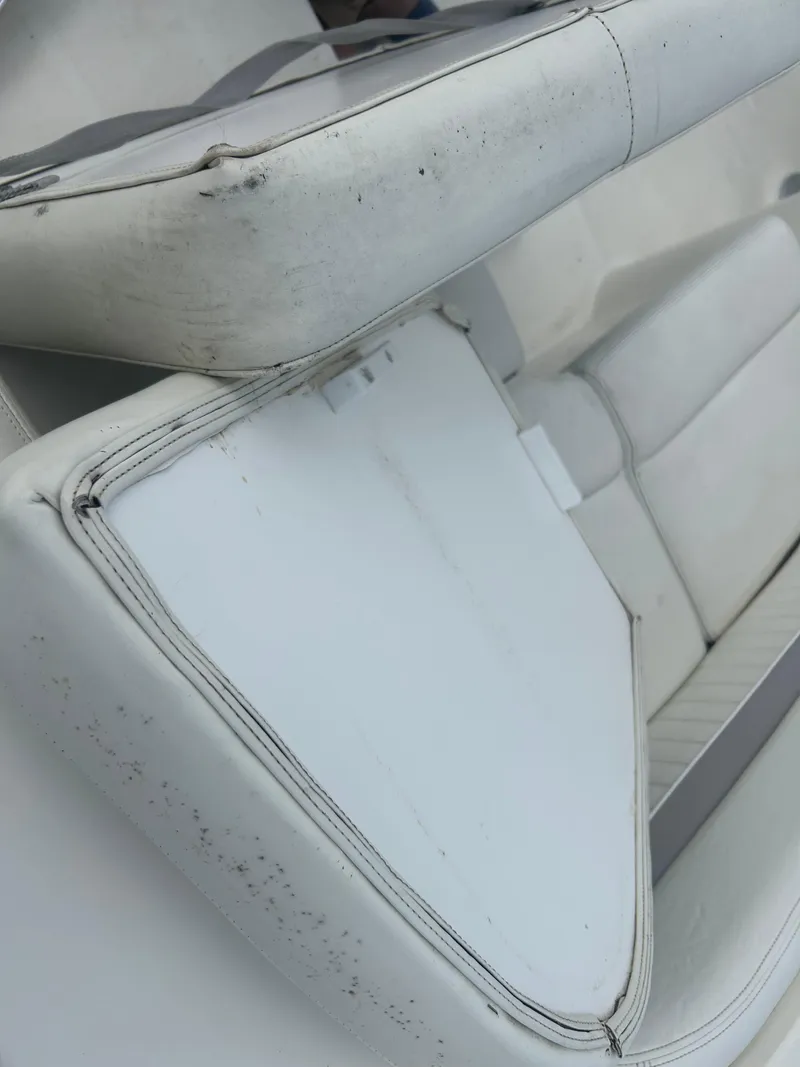 Slide: The Image of 2005 Stingray 250 LR boat interior with white seating and storage compartment. - 28