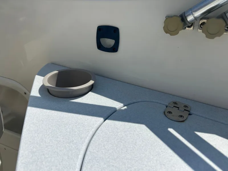 Slide: The Image of 2005 Stingray 250 LR boat interior with cup holder and storage compartment. - 31