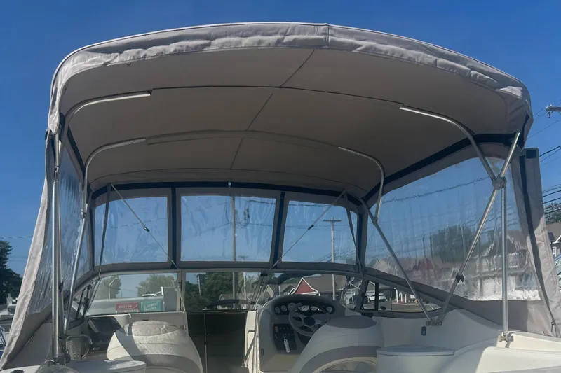 Slide: The Image of 2005 Stingray 250 LR boat with canopy and clear windows, interior view. - 4