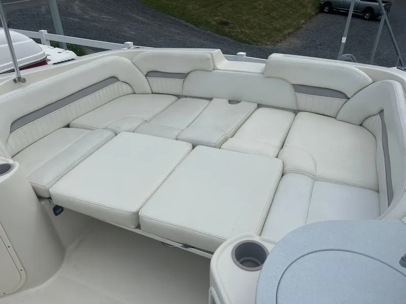Slide: The Image of 2005 Stingray 250 LR boat interior with spacious white cushioned seating area. - 8