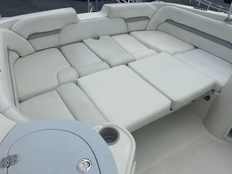Slide: The Image of 2005 Stingray 250 LR boat interior with white cushioned seating and cup holder. - 9