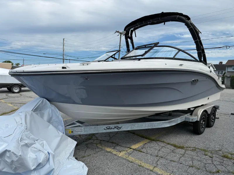 Slide: The Image of 2025 Sea Ray SPX 210 boat on trailer, parked outdoors under cloudy sky. - 0