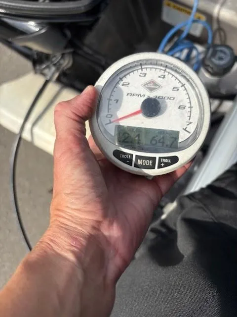Slide: The Image of Hand holding a tachometer on a 2023 Sun Tracker SportFish 20 DLX boat. - 11