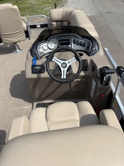 Slide: The Image of 2023 Sun Tracker SportFish 20 DLX boat interior with steering wheel and beige seating. - 6