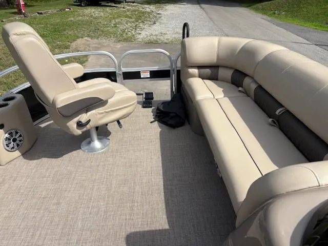 Slide: The Image of 2023 Sun Tracker SportFish 20 DLX pontoon boat interior with beige seating and captain's chair. - 9