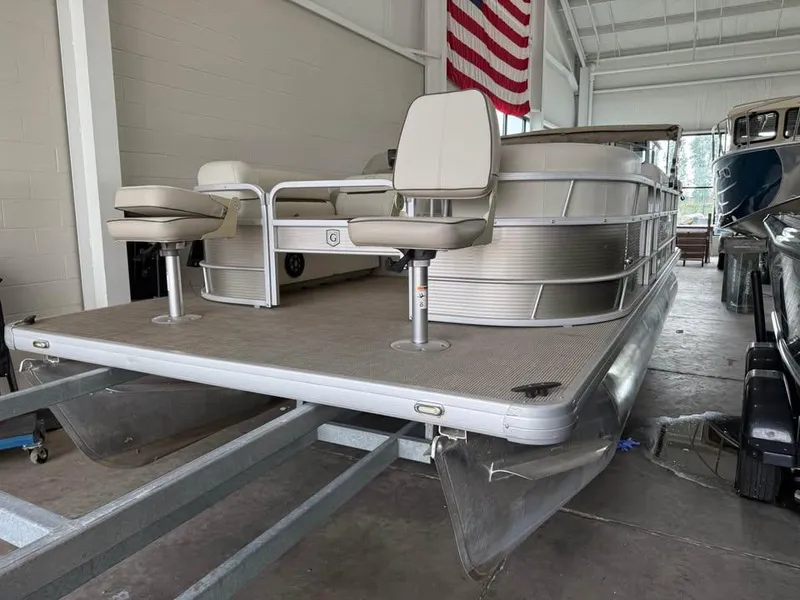 Slide: The Image of 2020 Godfrey SR 226 BF pontoon boat in indoor storage, featuring dual swivel seats. - 2
