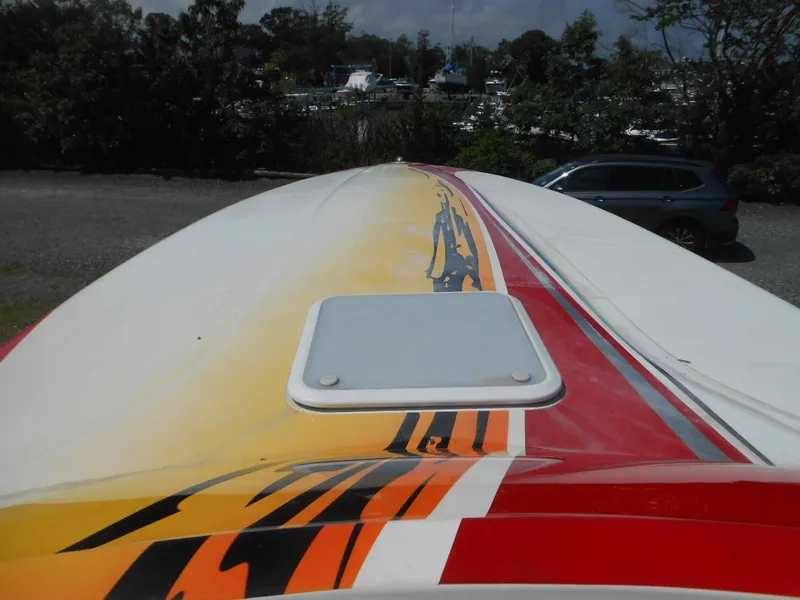 Slide: The Image of 2007 Sunsation 32 SS boat with vibrant red and yellow graphics, parked outdoors. - 15
