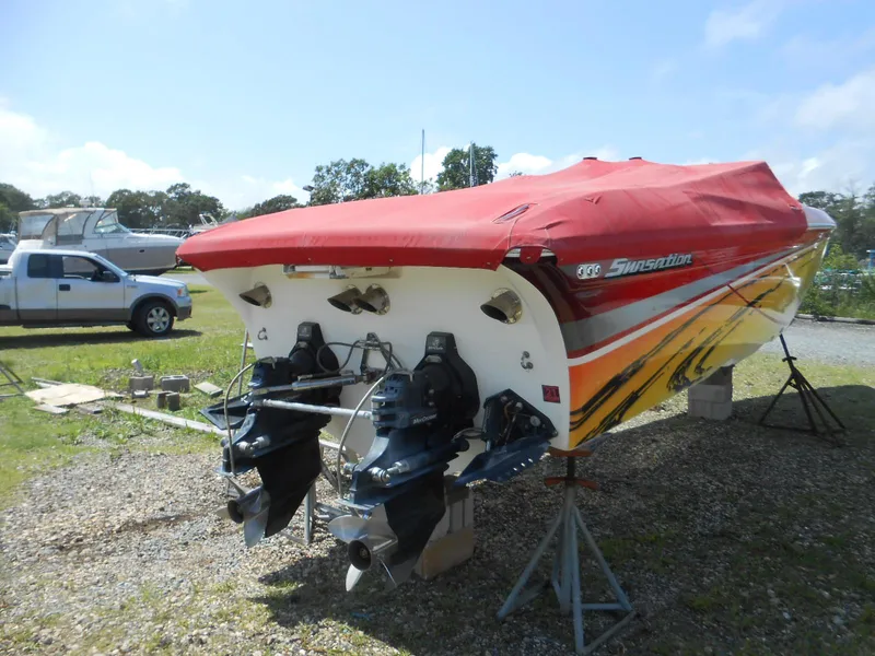 Slide: The Image of 2007 Sunsation 32 SS boat with red cover, dual outboard motors, parked on stands. - 16