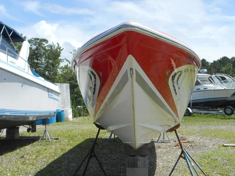 Slide: The Image of 2007 Sunsation 32 SS boat with red hull on stands, surrounded by other boats. - 18