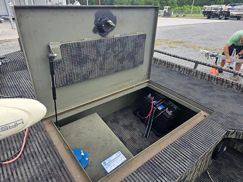 Slide: The Image of Open storage compartment of 2023 Low Country Swamp Fox 1854 boat, revealing battery inside. - 11