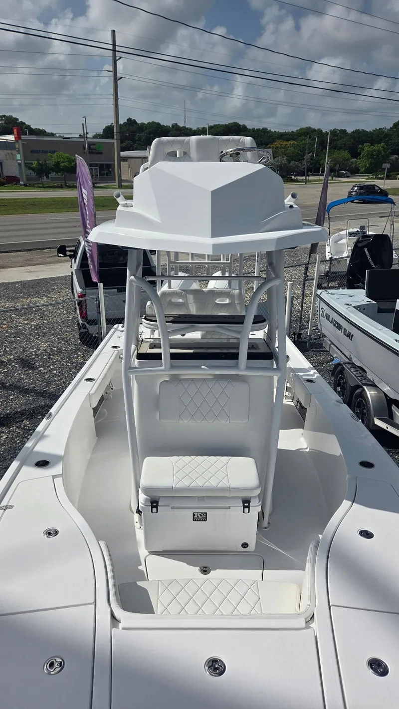 Slide: The Image of 2024 Blazer Bay 2700 Hybrid Bay boat, white exterior, parked outdoors. - 4