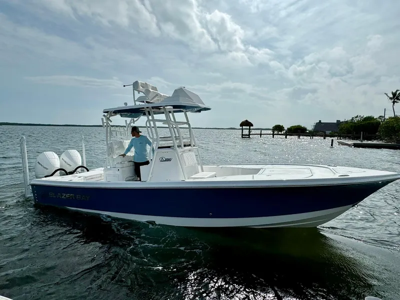 Slide: The Image of 2024 Blazer Bay 2700 Hybrid Bay boat on water, featuring dual Mercury engines. - 6