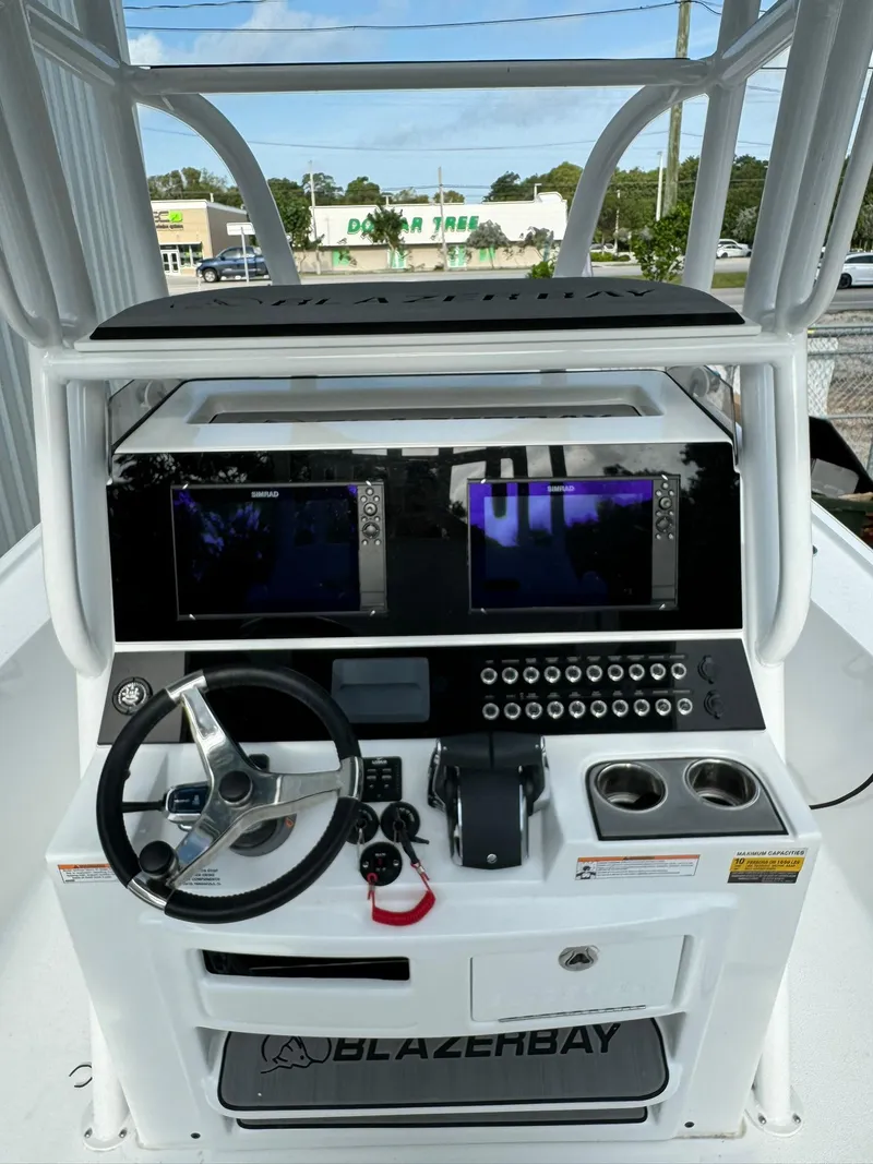 Slide: The Image of 2024 Blazer Bay 2700 Hybrid Bay boat dashboard with dual screens and steering wheel. - 7