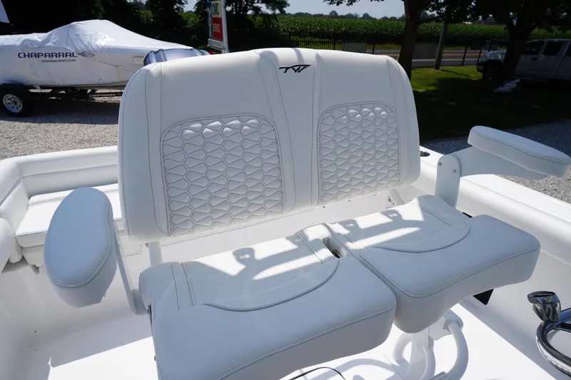 Slide: The Image of 2026 Tidewater 232 LXF boat with white cushioned seating and armrests, parked outdoors. - 36