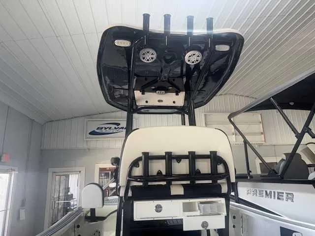 Slide: The Image of 2024 Tidewater 2210CB boat interior with T-top and rod holders in showroom. - 2