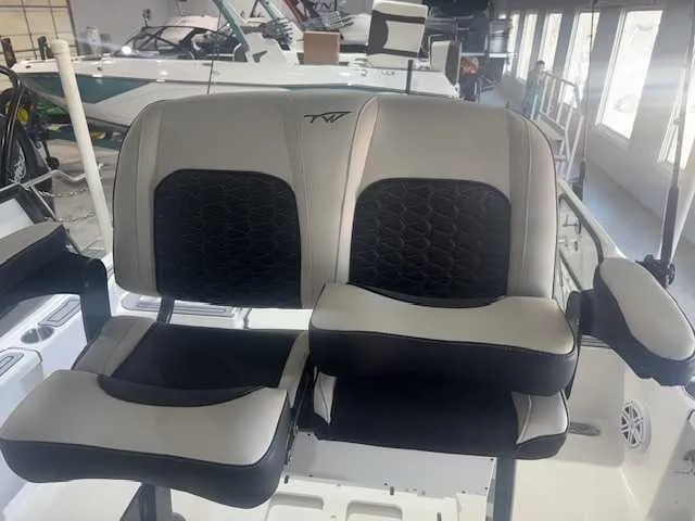 Slide: The Image of 2024 Tidewater 2210CB boat seats with black and gray upholstery in showroom. - 8