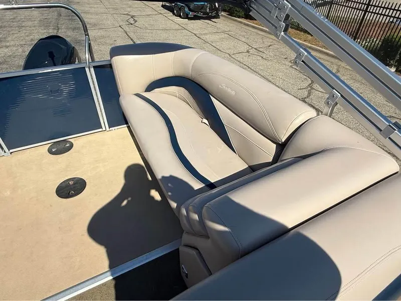 Slide: The Image of Beige seating on a 2014 Godfrey 220 SL pontoon boat, parked on pavement. - 13