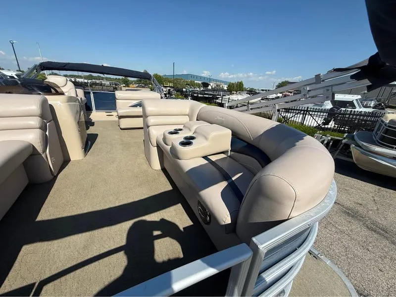 Slide: The Image of 2014 Godfrey 220 SL pontoon boat with beige seating and cup holders, docked outdoors. - 7