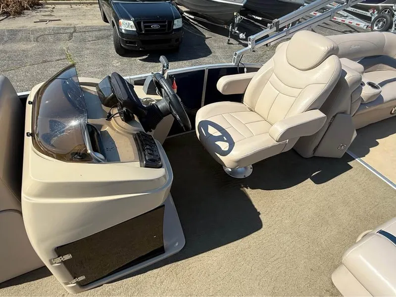 Slide: The Image of Captain's seat and helm of a 2014 Godfrey 220 SL boat, featuring beige upholstery. - 9