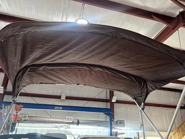Slide: The Image of Brown canopy of a 2012 Sun Tracker Party Barge 20 DLX in a warehouse setting. - 12