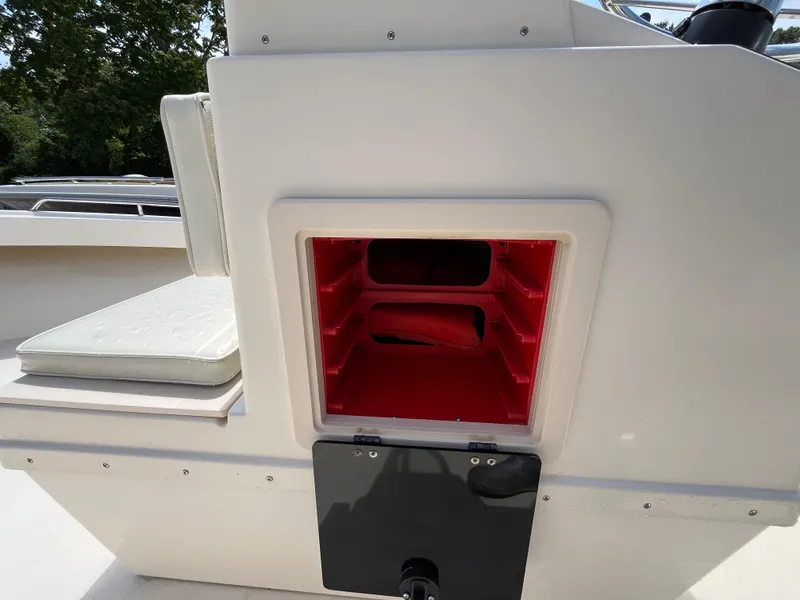 Slide: The Image of Open storage compartment on a 2005 Parker 2100 Special Edition boat, featuring red interior shelves. - 11
