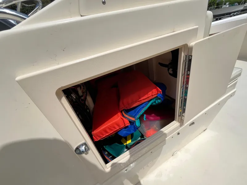 Slide: The Image of Open storage compartment on 2005 Parker 2100 Special Edition boat with life jackets inside. - 17