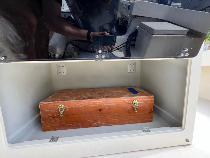 Slide: The Image of Open storage compartment in a 2005 Parker 2100 Special Edition boat with a wooden box inside. - 28