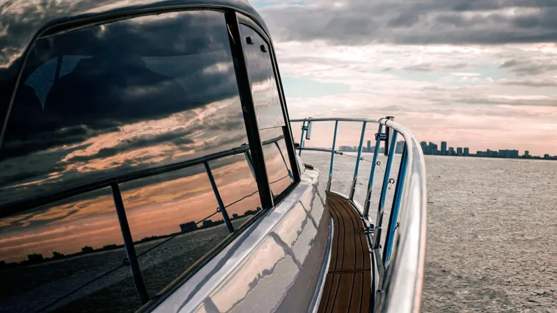 Slide: The Image of Sleek Hanover 415 yacht cruising at sunset, reflecting city skyline on water. - 10