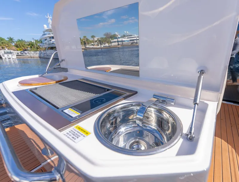 Slide: The Image of Outdoor kitchen on Hanover 415 yacht, featuring a grill and sink, docked by the water. - 20