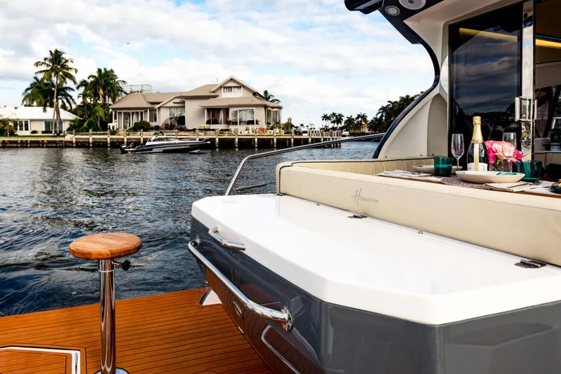 Slide: The Image of Luxurious Hanover 415 yacht with elegant dining setup, cruising near waterfront homes, 2025 model. - 23