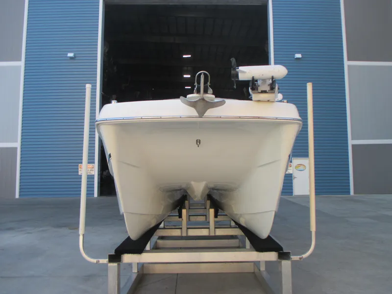 Slide: The Image of 2013 Carolina Cat 230 DC boat on trailer in front of blue warehouse. - 1