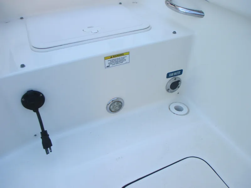 Slide: The Image of 2013 Carolina Cat 230 DC boat interior with raw water access and electrical outlet. - 11