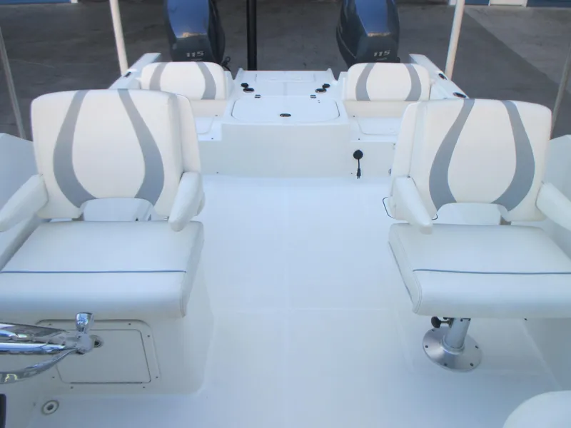 Slide: The Image of 2013 Carolina Cat 230 DC boat interior with white seating and dual engines. - 14