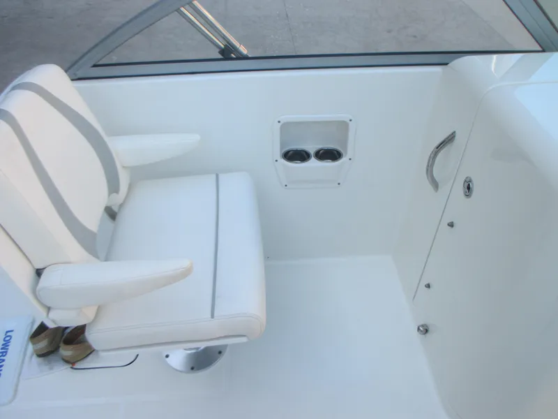 Slide: The Image of 2013 Carolina Cat 230 DC boat interior with white seating and cup holders. - 15