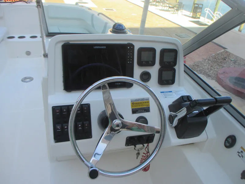 Slide: The Image of 2013 Carolina Cat 230 DC boat dashboard with steering wheel and navigation controls. - 17