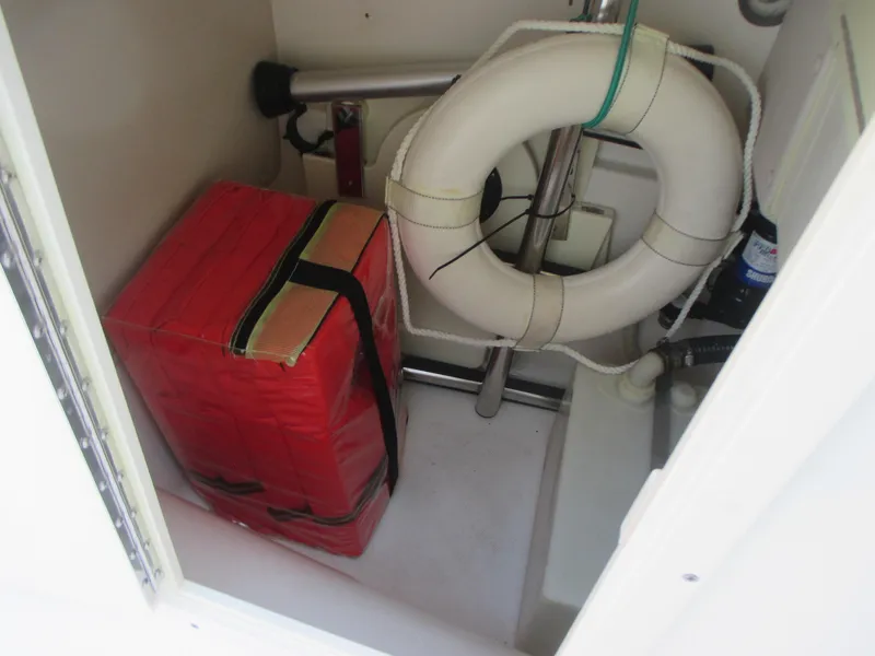 Slide: The Image of Storage compartment in a 2013 Carolina Cat 230 DC with life preserver and red emergency kit. - 20
