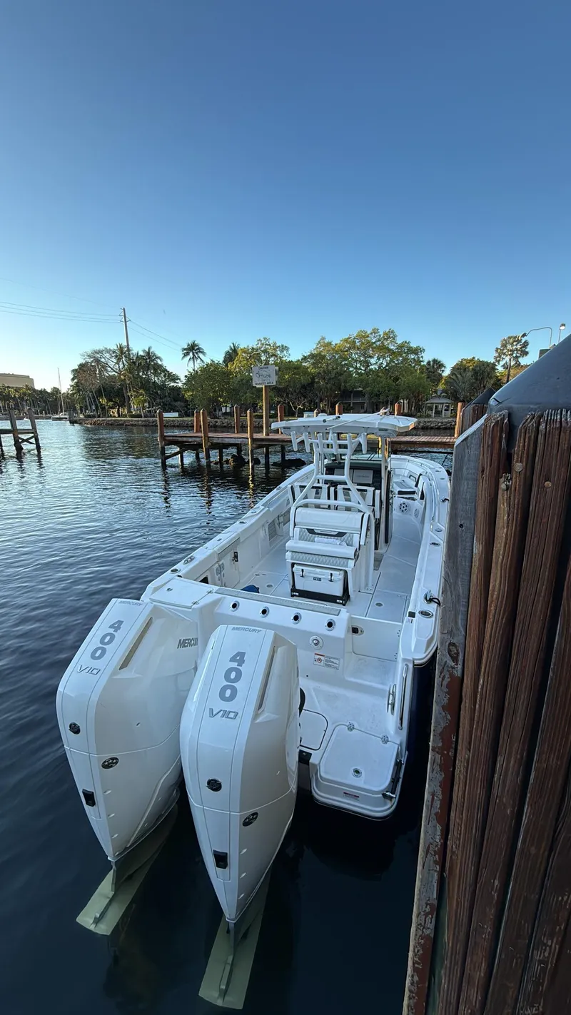 Slide: The Image of 2025 Blackfin 302 CC boat docked with twin 400 V10 engines, calm water backdrop. - 5