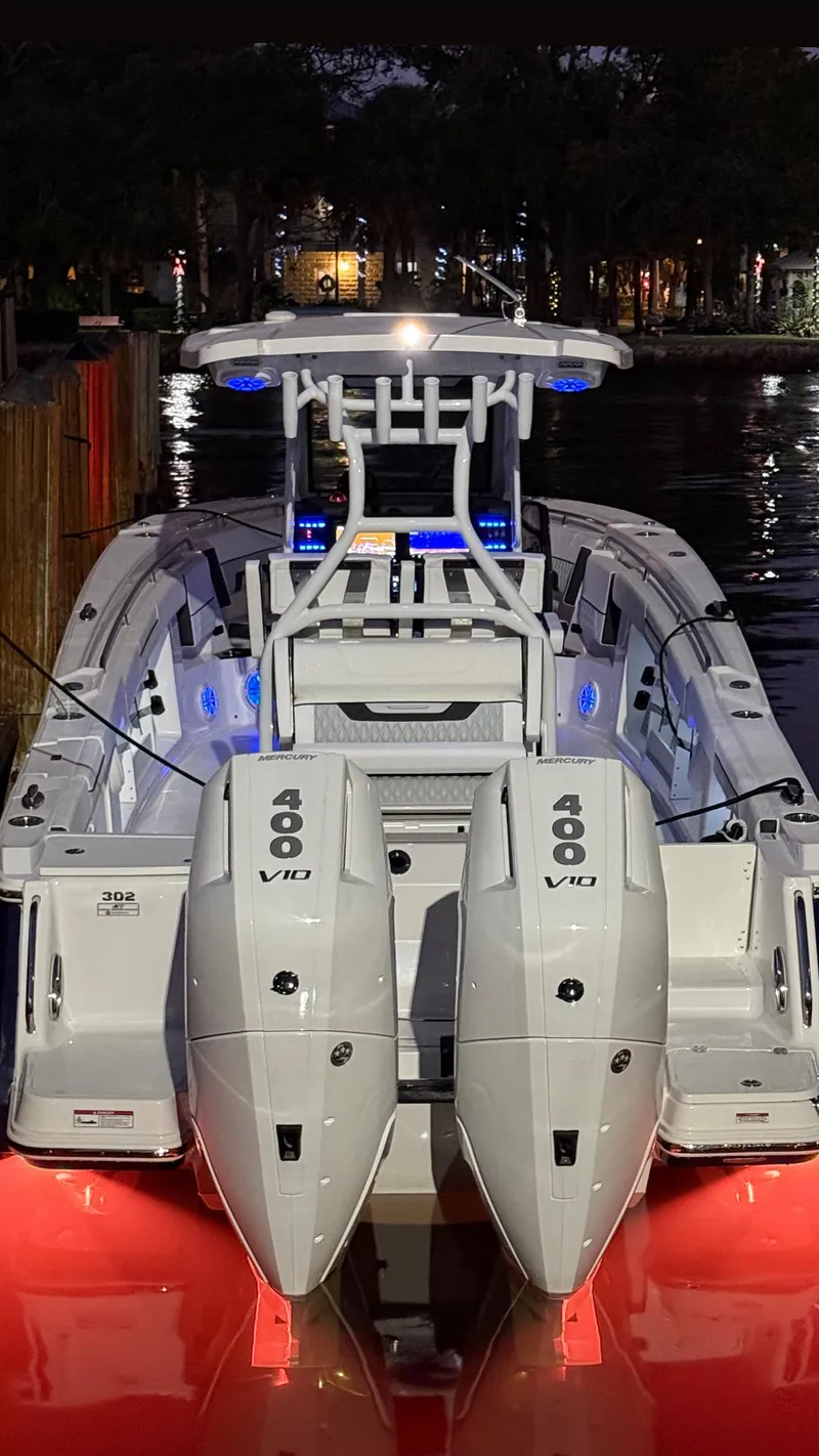 Slide: The Image of 2025 Blackfin 302 CC boat with dual 400 V10 engines, illuminated at night. - 6