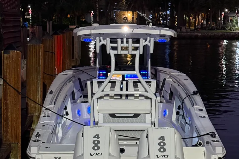 Slide: The Image of 2025 Blackfin 302 CC boat docked at night with illuminated interior and twin Mercury 400 engines. - 8