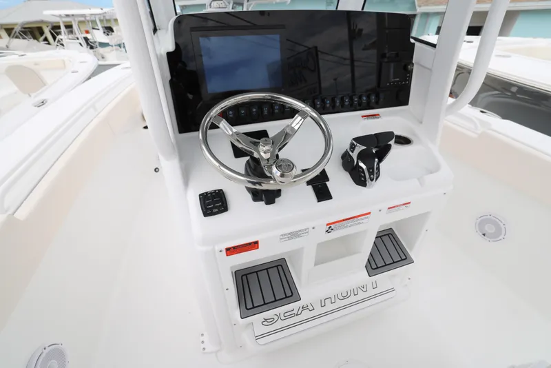 Slide: The Image of 2025 Sea Hunt Gamefish 27 Forward Seating boat console with steering wheel and controls. - 7