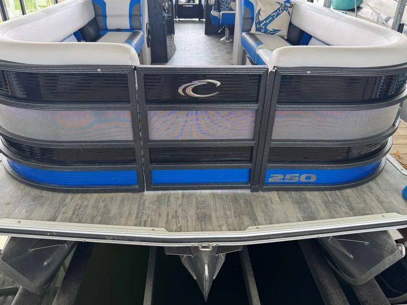Slide: The Image of 2022 Crest Caribbean RS 250 SLRC pontoon boat with blue and black accents. - 12