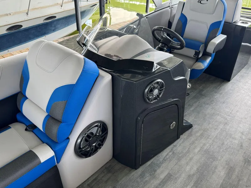 Slide: The Image of 2022 Crest Caribbean RS 250 SLRC boat interior with blue and gray seating and steering console. - 16
