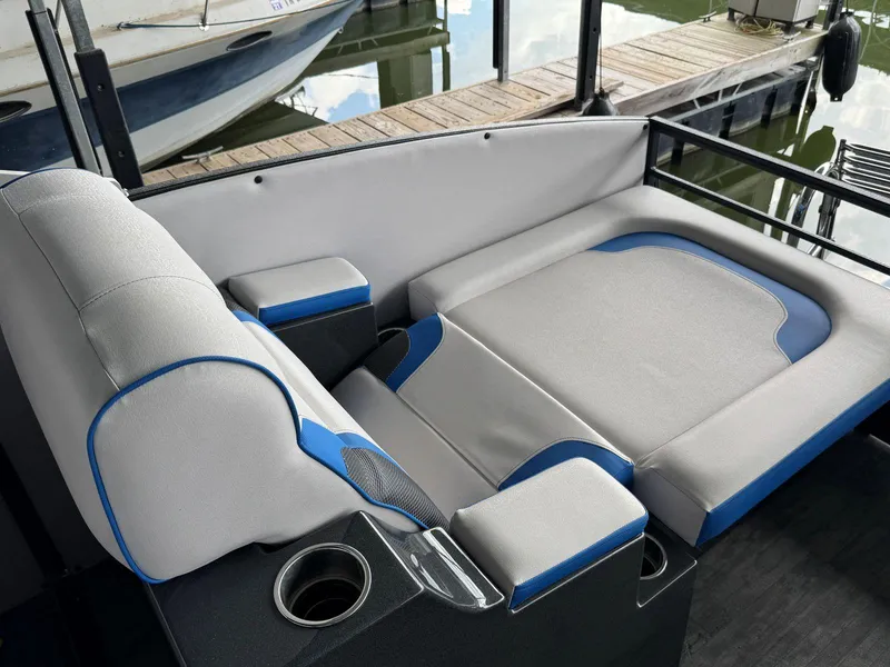 Slide: The Image of 2022 Crest Caribbean RS 250 SLRC boat interior with gray and blue seating near a dock. - 24