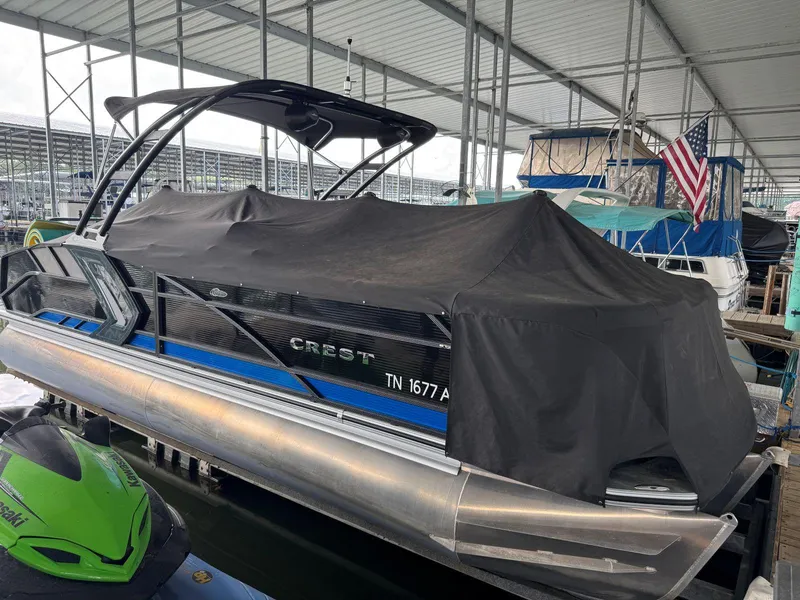 Slide: The Image of 2022 Crest Caribbean RS 250 SLRC pontoon boat covered at marina dock. - 37