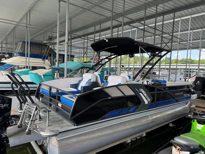 Slide: The Image of 2022 Crest Caribbean RS 250 SLRC pontoon boat docked in a marina. - 4