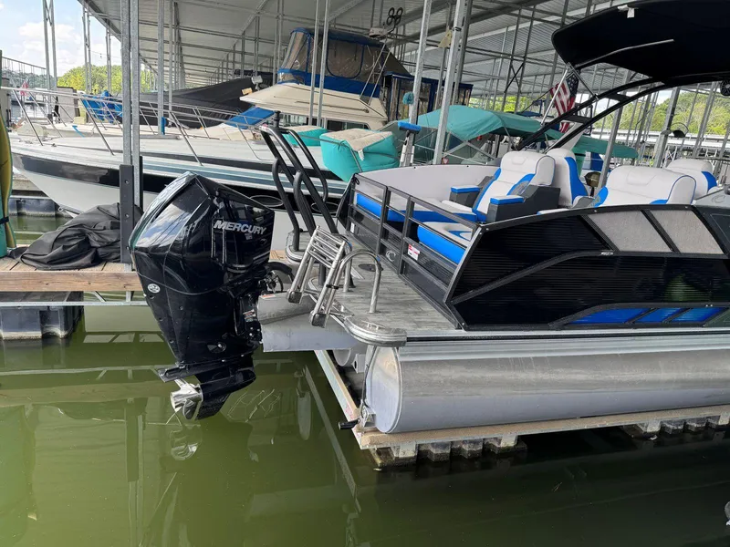 Slide: The Image of 2022 Crest Caribbean RS 250 SLRC pontoon boat with Mercury outboard motor docked in marina. - 5